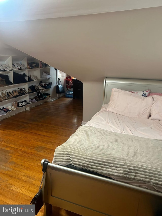 bedroom with dark hardwood / wood-style floors and vaulted ceiling