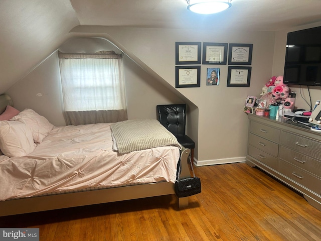 bedroom featuring lofted ceiling and hardwood / wood-style floors