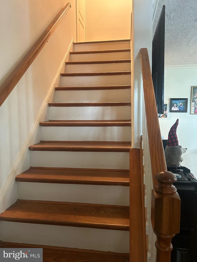 stairway with a textured ceiling