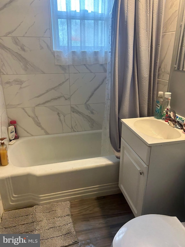 bathroom with wood-type flooring, vanity, and shower / bathtub combination with curtain