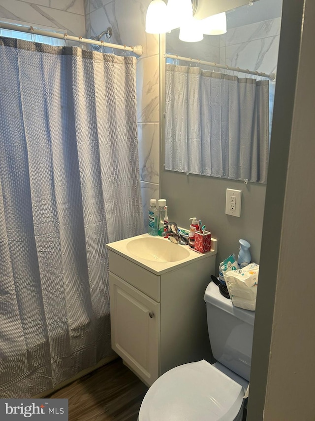 bathroom with wood-type flooring, vanity, and toilet