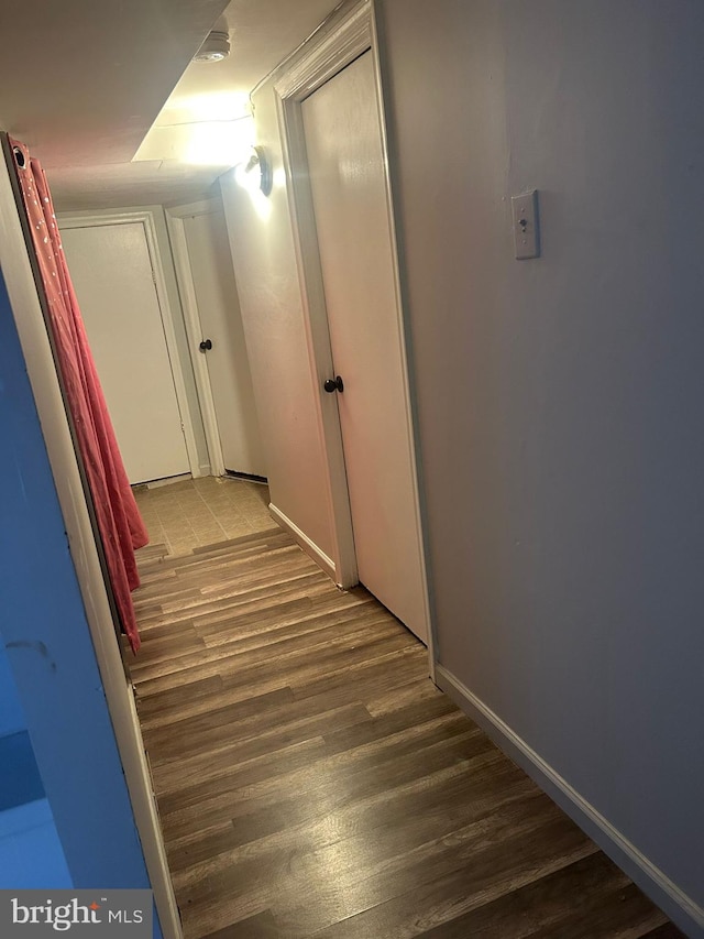 hallway with hardwood / wood-style flooring