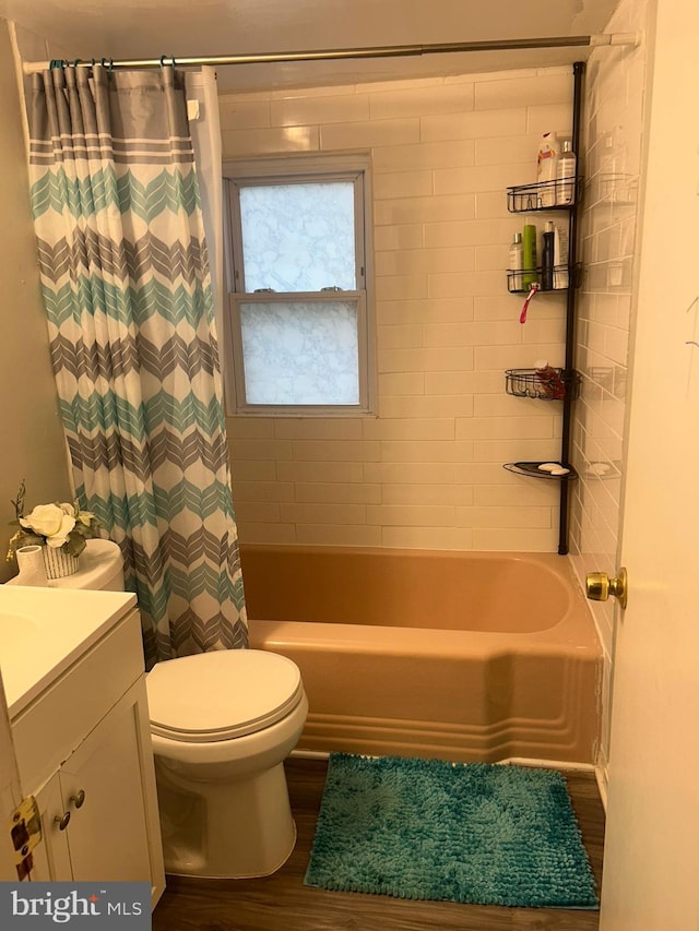 full bathroom with hardwood / wood-style flooring, shower / tub combo, toilet, and vanity