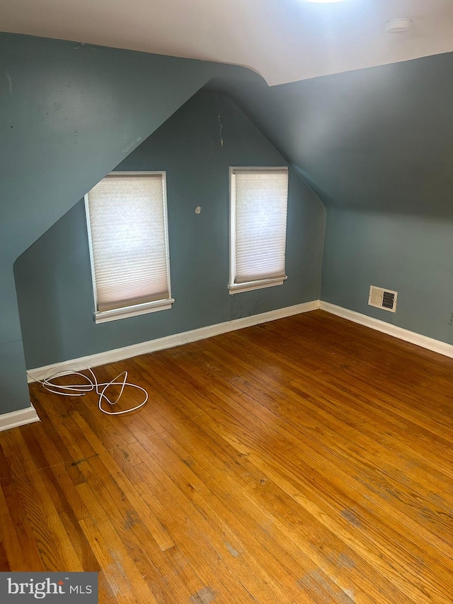 bonus room with hardwood / wood-style floors, vaulted ceiling, and a wealth of natural light