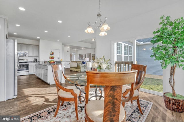 dining room with wood-type flooring and an inviting chandelier