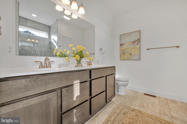 bathroom featuring tile patterned floors, vanity, toilet, and tiled shower