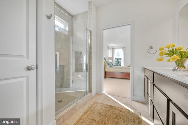 bathroom with an enclosed shower, vanity, tile patterned floors, and a wealth of natural light