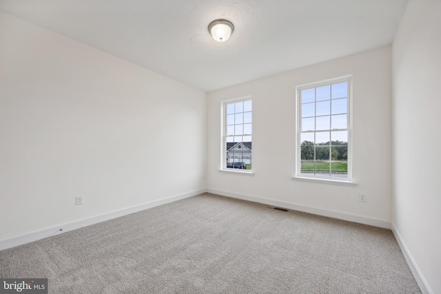 unfurnished room featuring light colored carpet