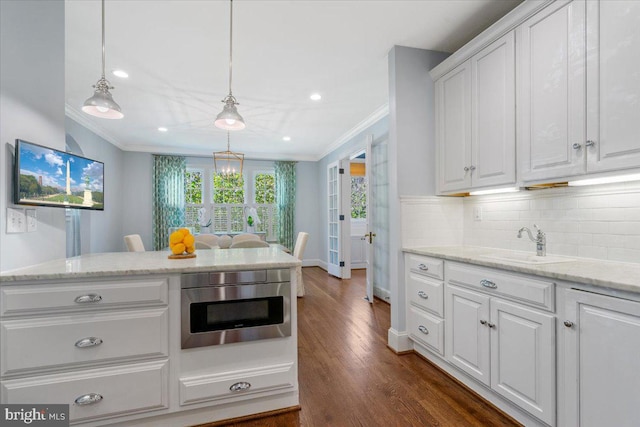 kitchen featuring white cabinetry, decorative light fixtures, dark hardwood / wood-style flooring, sink, and stainless steel oven