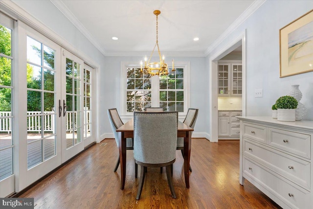 dining area featuring dark wood-type flooring, french doors, a notable chandelier, and ornamental molding