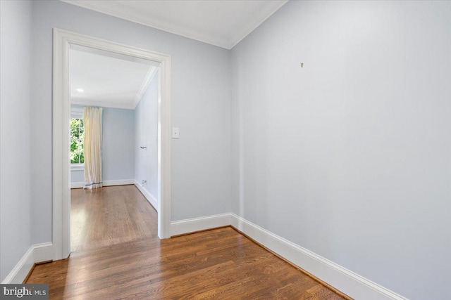 empty room featuring crown molding and dark wood-type flooring