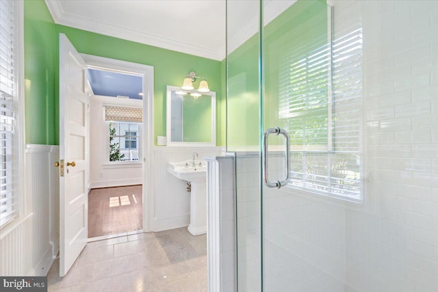 bathroom with wood-type flooring, a shower with door, and crown molding