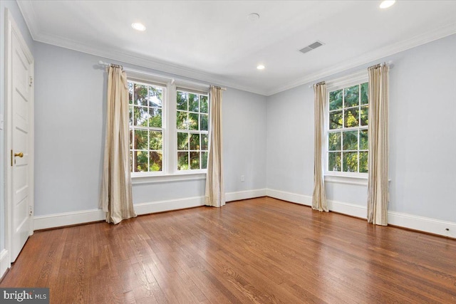 empty room with crown molding and hardwood / wood-style floors