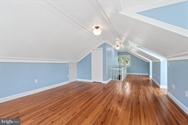 bonus room with lofted ceiling and hardwood / wood-style floors