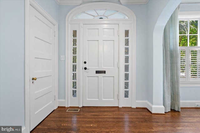 entrance foyer with ornamental molding and dark hardwood / wood-style floors