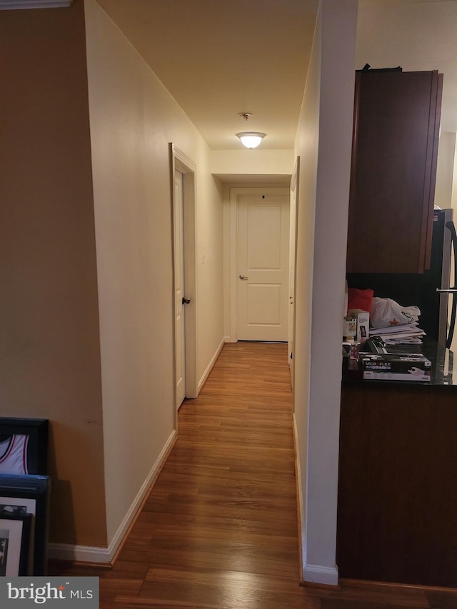 hallway with hardwood / wood-style floors