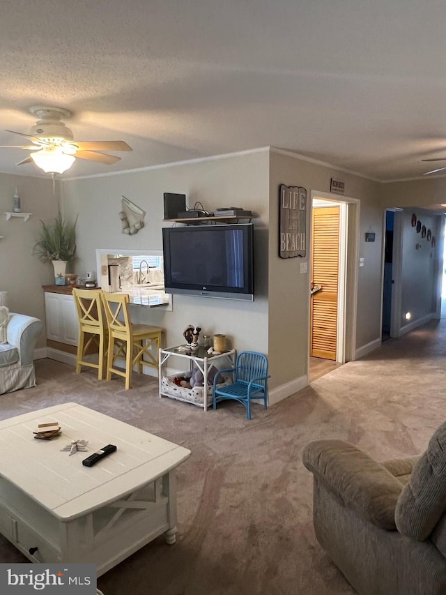 living room featuring ceiling fan, carpet flooring, and a textured ceiling