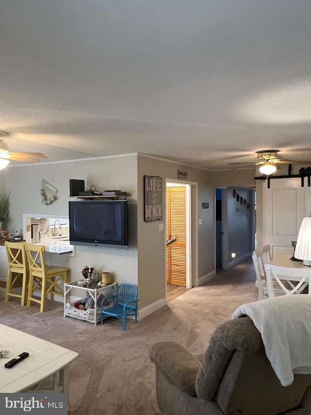 carpeted living room featuring ceiling fan and crown molding