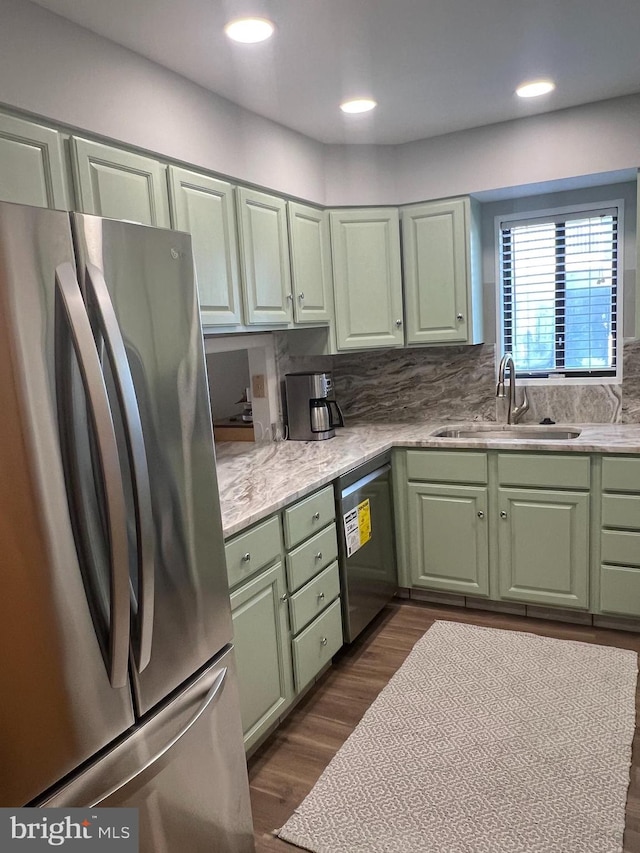 kitchen featuring sink, tasteful backsplash, dishwashing machine, dark hardwood / wood-style flooring, and stainless steel fridge