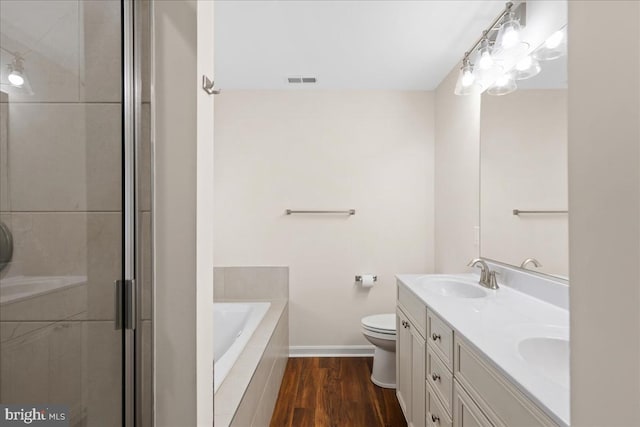 full bathroom with wood-type flooring, independent shower and bath, toilet, and double sink vanity