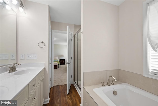 bathroom with hardwood / wood-style floors, vanity, and shower with separate bathtub