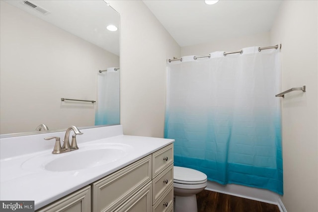 bathroom with wood-type flooring, vanity, and toilet