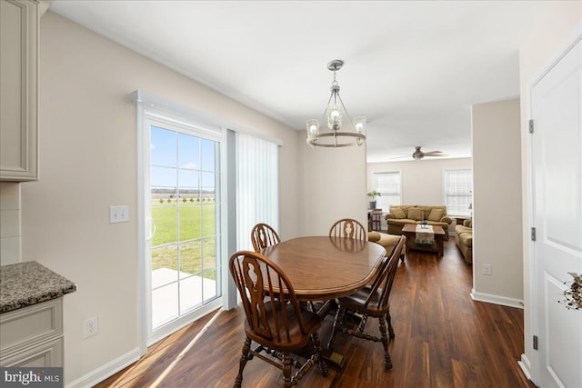 dining area with ceiling fan with notable chandelier and dark hardwood / wood-style floors