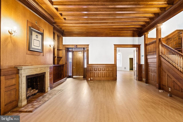 unfurnished living room featuring beamed ceiling and light hardwood / wood-style flooring