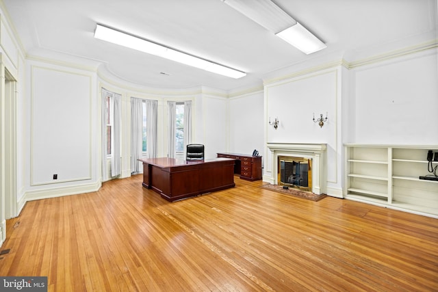 unfurnished office with ornamental molding and light wood-type flooring