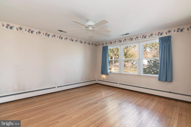 spare room with light wood-type flooring, ceiling fan, and a baseboard heating unit