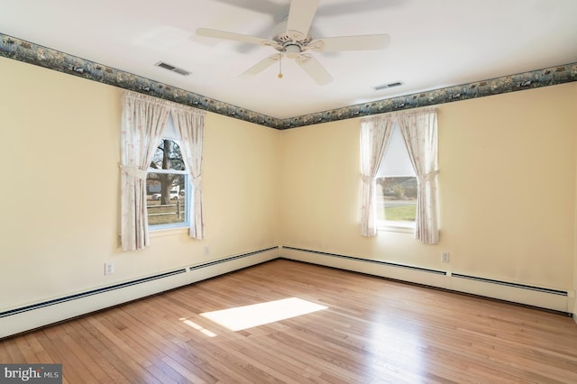 spare room with ceiling fan, light wood-type flooring, and baseboard heating