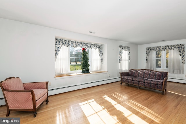 living area featuring light hardwood / wood-style floors and a baseboard heating unit