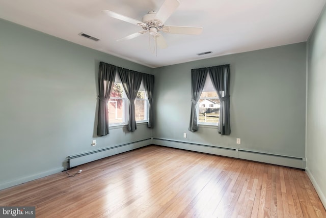 empty room with baseboard heating, ceiling fan, and light hardwood / wood-style floors