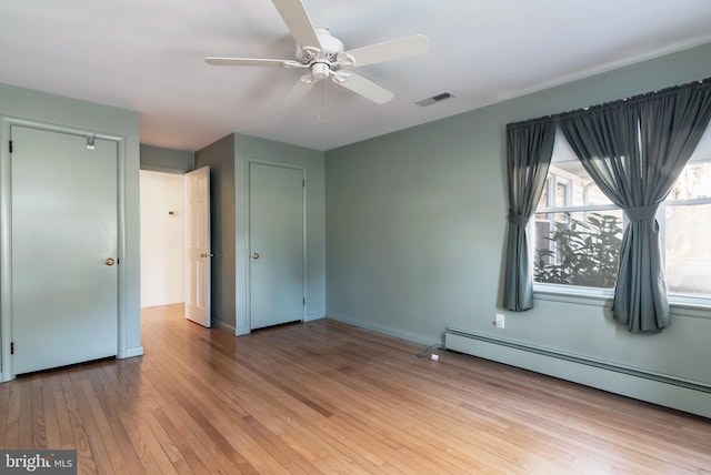 unfurnished bedroom with ceiling fan, a baseboard radiator, and light wood-type flooring