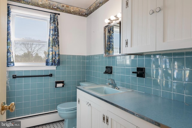 bathroom featuring vanity, a baseboard radiator, tile walls, tile patterned flooring, and toilet