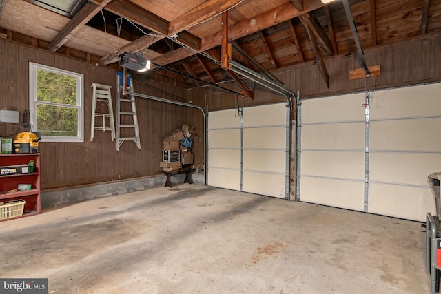 garage with wooden walls and a garage door opener