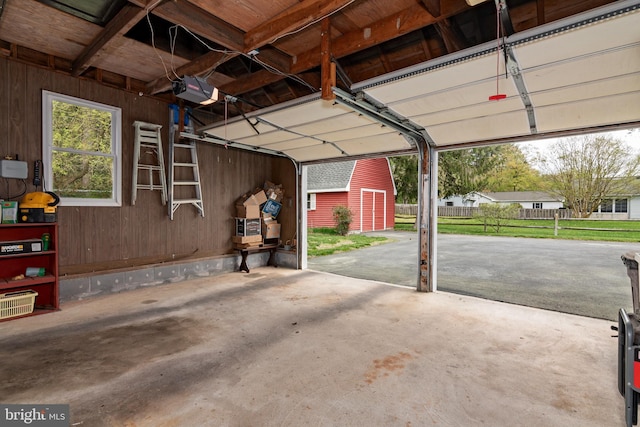 garage featuring wood walls and a garage door opener