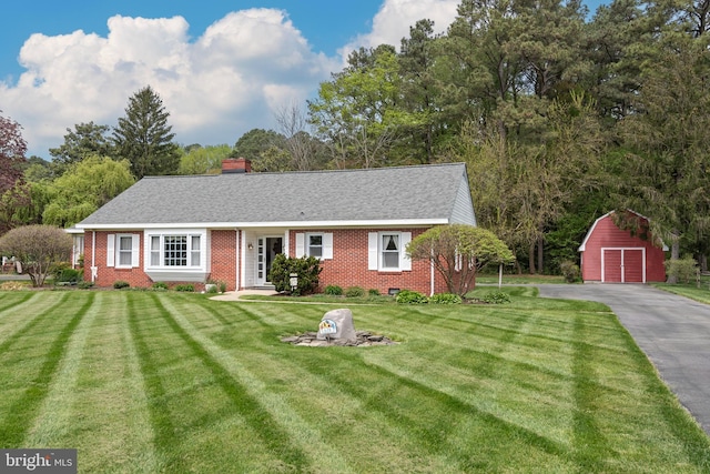 view of front of home featuring a front lawn and an outdoor structure