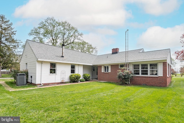 back of property featuring a lawn and cooling unit