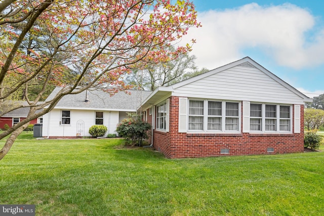 exterior space with central AC and a yard