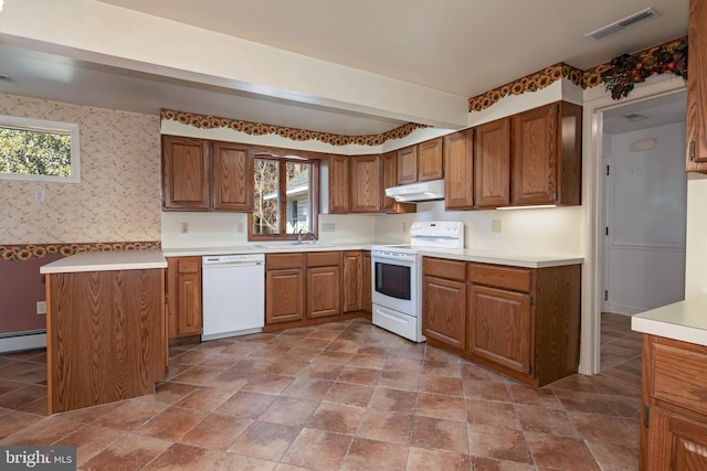 kitchen featuring white appliances, baseboard heating, and sink