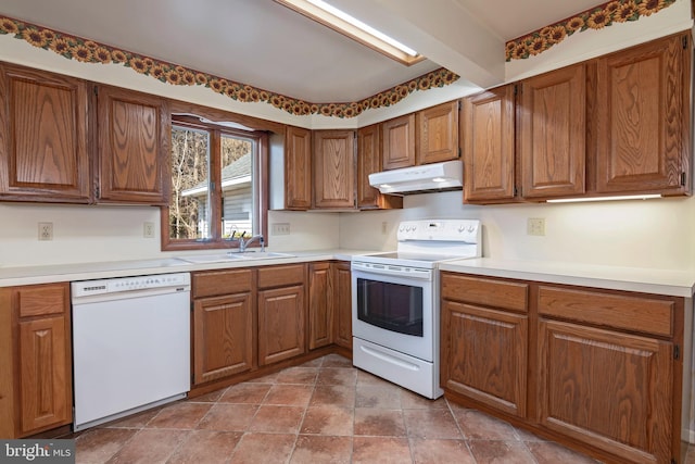 kitchen featuring beam ceiling, sink, and white appliances