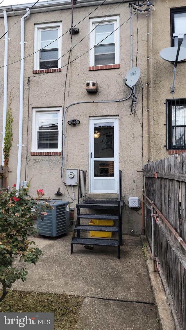 rear view of property with a patio area and central AC