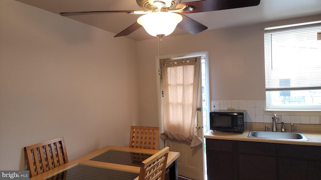 kitchen featuring backsplash, ceiling fan, and sink