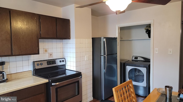 kitchen with ceiling fan, dark brown cabinets, black refrigerator, stainless steel range with electric cooktop, and washer / clothes dryer