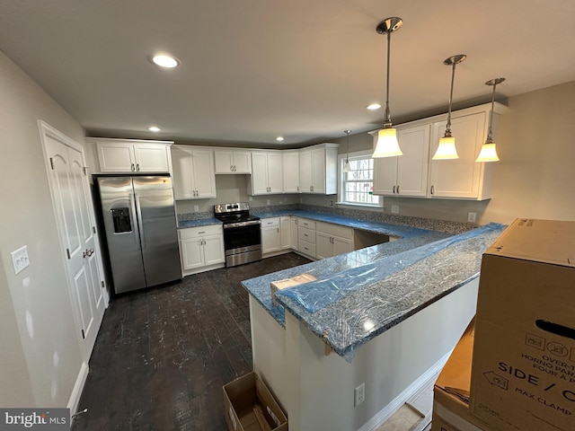 kitchen with white cabinetry, stainless steel appliances, a kitchen breakfast bar, decorative light fixtures, and kitchen peninsula