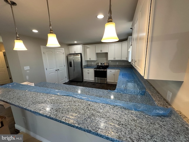 kitchen with stone countertops, decorative light fixtures, white cabinetry, and appliances with stainless steel finishes