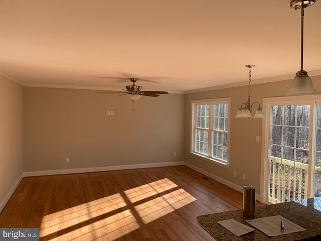 empty room featuring hardwood / wood-style flooring, ornamental molding, and a healthy amount of sunlight