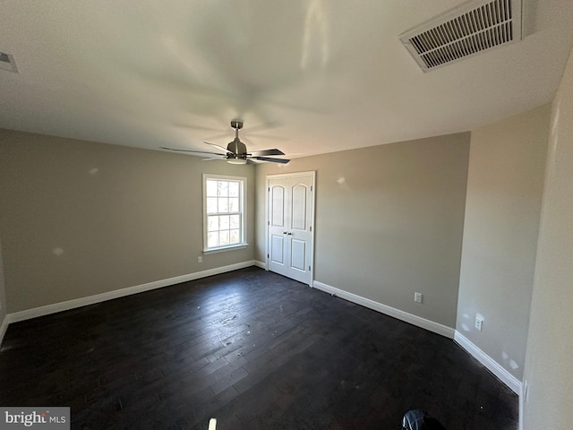 empty room with dark hardwood / wood-style flooring and ceiling fan