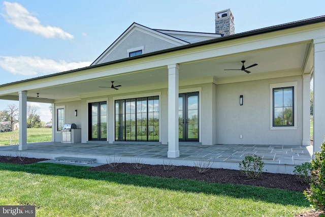 back of house featuring a lawn and ceiling fan